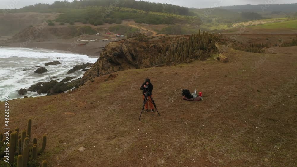 surf and nature photographer on the coast of chile, pacific ocean, pichilemu punta de lobos, drone footage, orbital plane