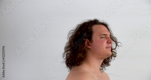 closeup of shirtless young man turned to the left and shaking his hair on white background photo