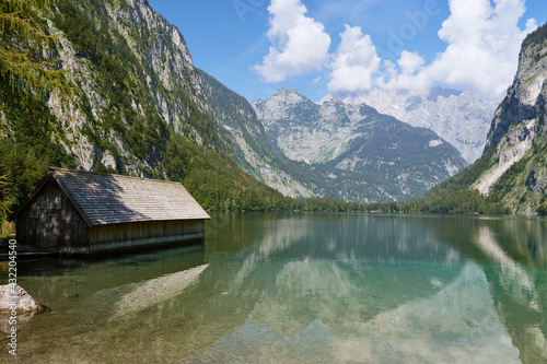 Traditional wooden boat house at Lake Obersee and mountain range in Berchtesgadener Land, Bavaria, Germany.