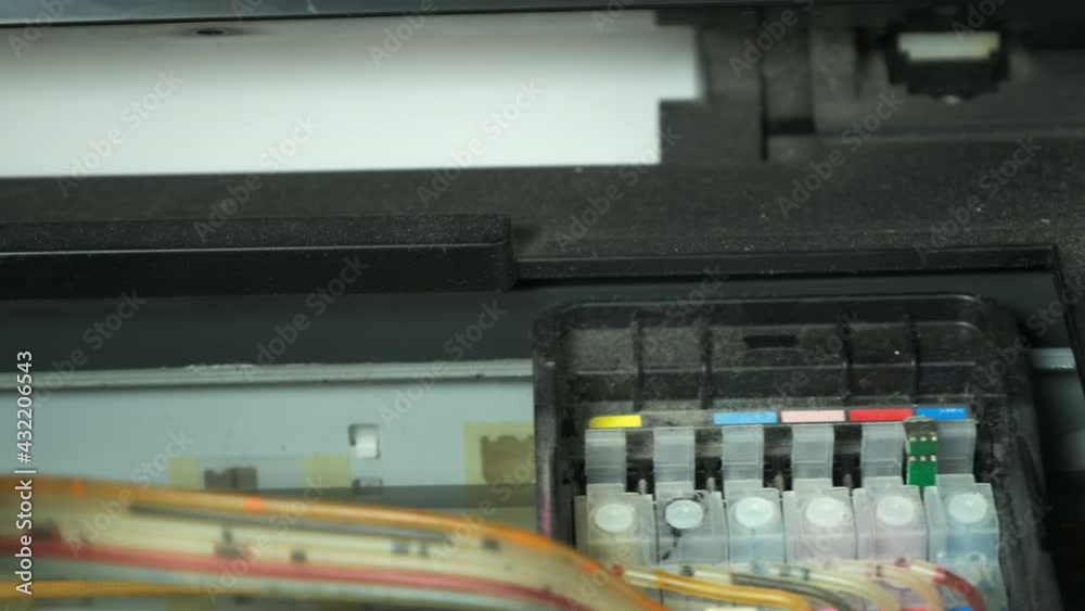 Continuous ink supply system is working in printer moving inside, closeup view. Printing new inkjet printer for launch, CISS. Small printer for use and printing at home, filled with only black paint. Continuous ink supply system is working in printer moving inside, closeup view. Printing new inkjet printer for launch, CISS. Small printer for use and printing at home, filled with only black paint.