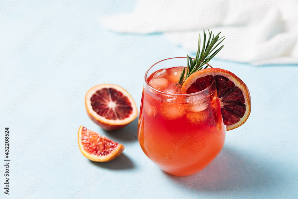 Delicious Blood Orange Cocktail on light blue background. Summer cocktails, lemonade, refreshing drinks, low alcohol mocktail concept. Copy space Delicious Blood Orange Cocktail on light blue background. Summer cocktails, lemonade, refreshing drinks, low alcohol mocktail concept. Copy space