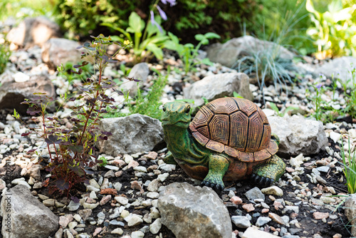 Turtle in the garden. Decorative sculptures. Landscape decor. A stone in the garden. Green garden.