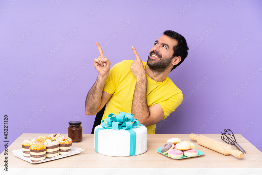 Man in a table with a big cake pointing with the index finger a great idea Man in a table with a big cake pointing with the index finger a great idea
