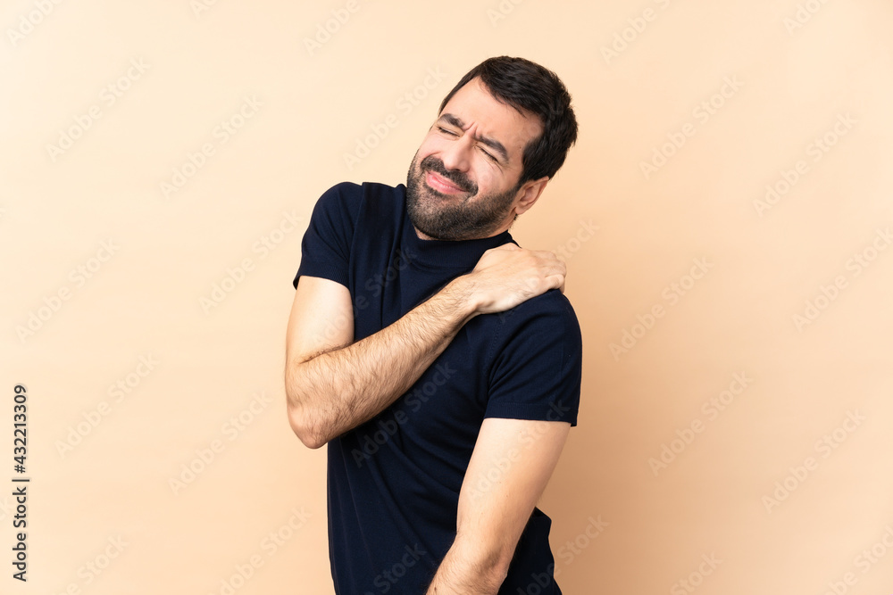 Caucasian handsome man over isolated background suffering from pain in shoulder for having made an effort Caucasian handsome man over isolated background suffering from pain in shoulder for having made an effort