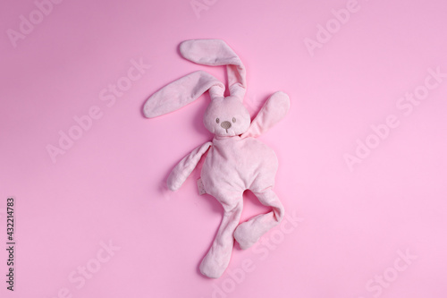 top view of cute pink plush rabbit dancing on pink background with copy space