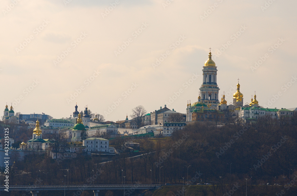 Fototapeta premium Scenic spring view of famous Kyiv's hills against blue sky. Scenic landscape of ancient Kyiv Pechersk Lavra. It is a historic Orthodox Christian monastery. Kyiv, Ukraine