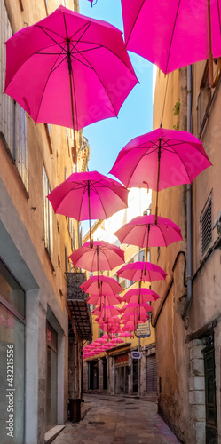 Ombrelles roses d  corant une ruelle aux couleurs chaudes