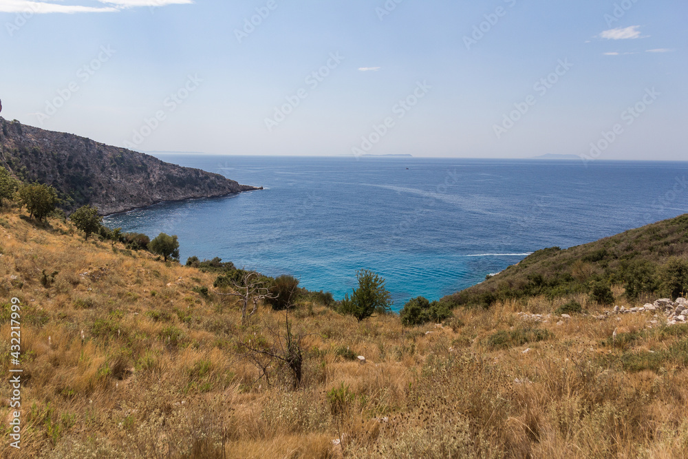 Mountain slope descending to the turquoise sea, Albania. Fauna of the mediterranean. Travel theme.