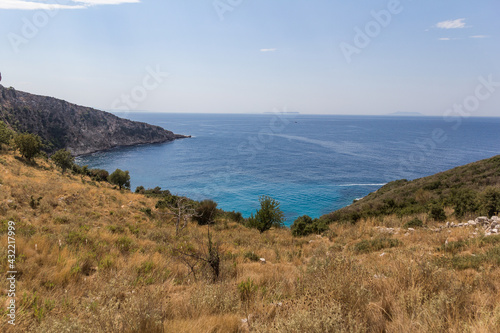 Fototapeta Naklejka Na Ścianę i Meble -  Mountain slope descending to the turquoise sea, Albania. Fauna of the mediterranean. Travel theme.