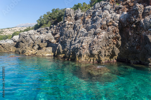 Amazing turquoise transparent sea and rocks surrounded by vegetation, Albania. Travel and vacation theme