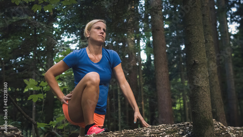 Tableau sur toile Close up of a Caucasian woman doing hip flexor stretch in the forest, raising he