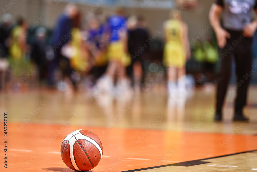 Basketball ball on the parquet with team and referee in the background. Basketball ball on the parquet with team and referee in the background.
