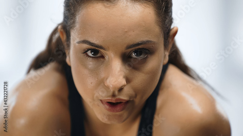 close up of exhausted and sweaty sportswoman working out in gym.