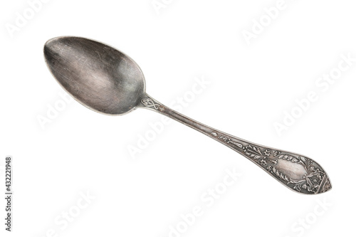 Top view of an old tablespoon with embossed patterns on the handle. The spoon lies diagonally across the image