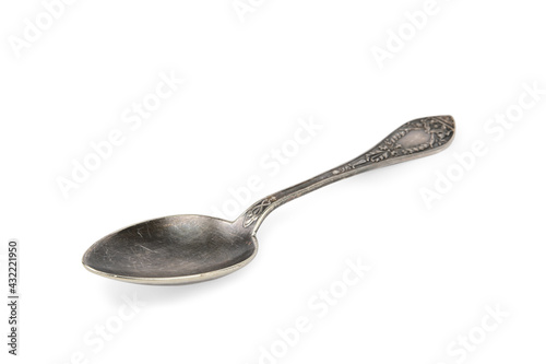 Side view of an old, patterned, black-tinted table spoon