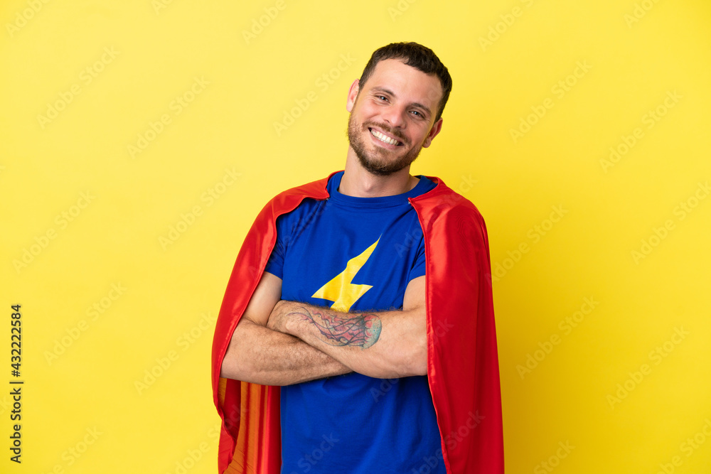 Super Hero Brazilian man isolated on yellow background with arms crossed and looking forward Super Hero Brazilian man isolated on yellow background with arms crossed and looking forward