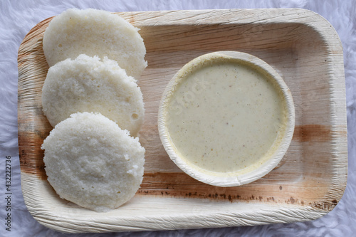 Delicious South indian popular breakfast Idli with white chutney served in plate.