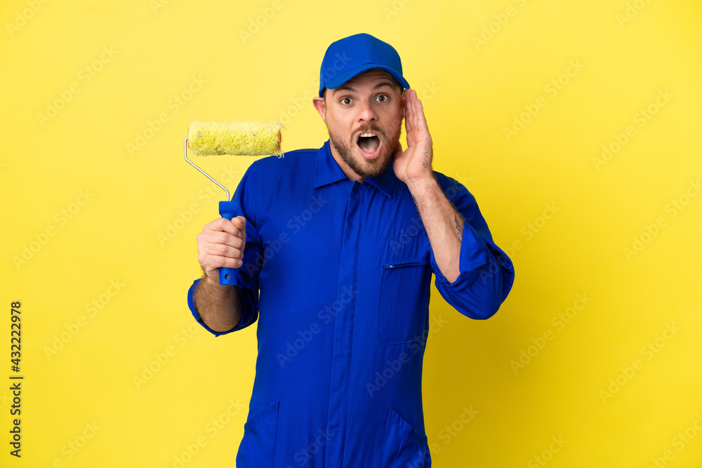 Painter Brazilian man isolated on yellow background with surprise and shocked facial expression