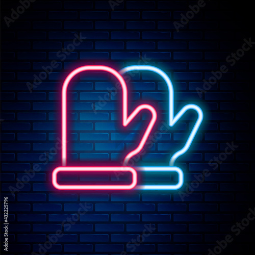 Glowing neon line Christmas mitten icon isolated on brick wall background. Colorful outline concept. Vector