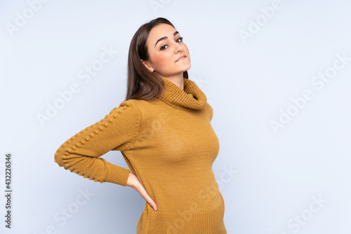 Young caucasian woman isolated on blue background suffering from backache for having made an effort