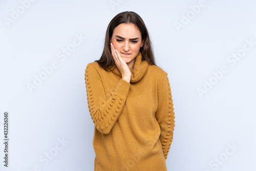 Young caucasian woman isolated on blue background with toothache © luismolinero