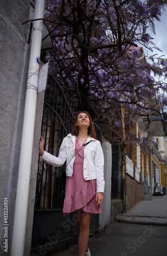 a young woman walks along a narrow street of the spring city