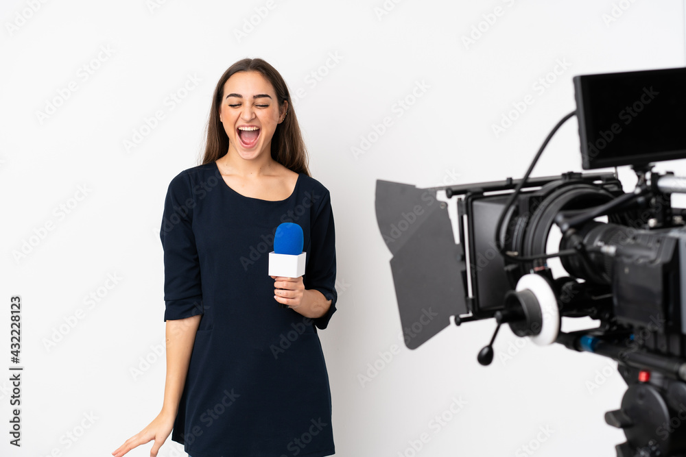 Reporter woman holding a microphone and reporting news isolated on white background shouting to the front with mouth wide open Reporter woman holding a microphone and reporting news isolated on white background shouting to the front with mouth wide open