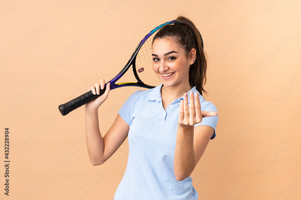 Young woman tennis player over isolated wall Young woman tennis player over isolated wall