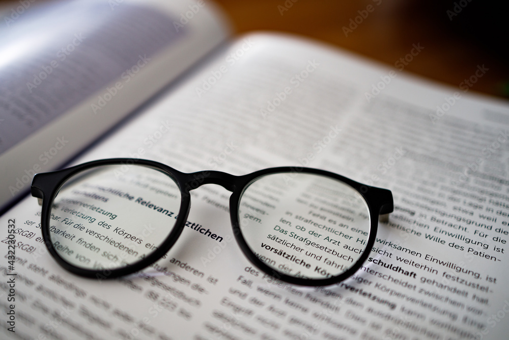 Black framed reading glasses on the book, close up Black framed reading glasses on the book, close up