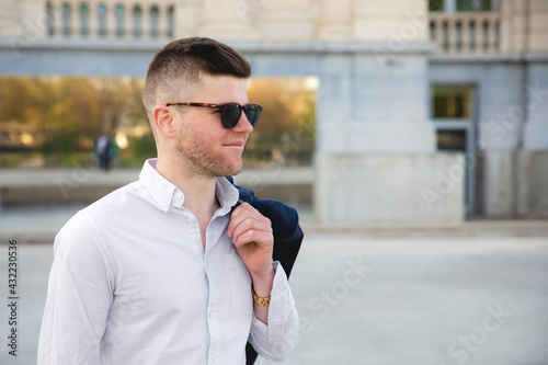 Bilde på lerret Un jeune homme la veste sur l'épaule au printemps