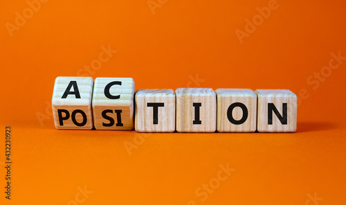 Action or position symbol. Turned wooden cubes and changed the word position to action. Beautiful orange background, copy space. Business and action or position concept.