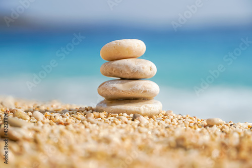 Pyramid stones balance on the sand of the beach. The object is in focus  the background is blurred. Zen balance  minimalism  harmony and peace