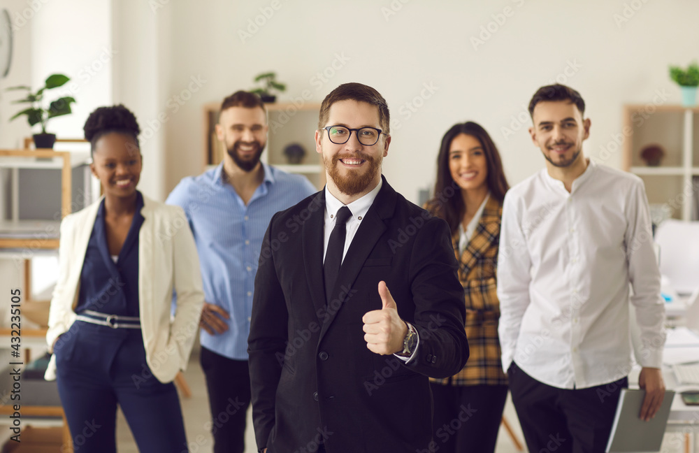 Good company business service recommendation, leadership. Confident millennial male team leader posing in office with diverse multi-ethnic colleagues show thumb up. Client express positive feedback Good company business service recommendation, leadership. Confident millennial male team leader posing in office with diverse multi-ethnic colleagues show thumb up. Client express positive feedback
