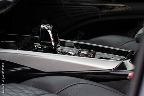 Close up of the automatic gearbox lever. Gear shift handle in a modern car. Modern car interior detail. © Roman