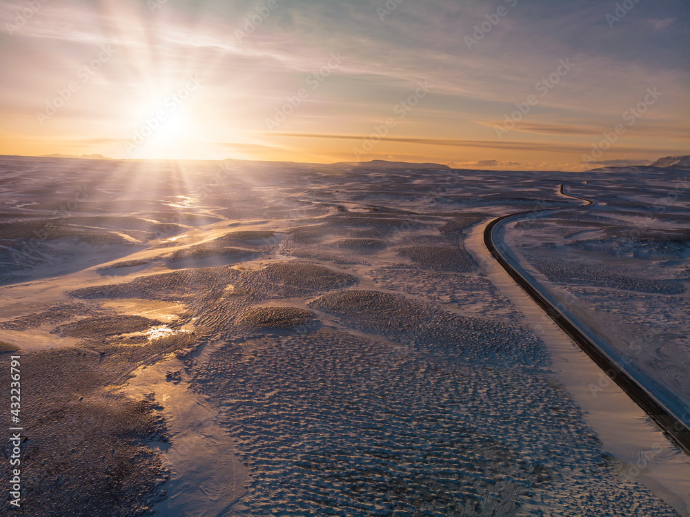Sunset in Icelandic frozen desert with empty road Sunset in Icelandic frozen desert with empty road