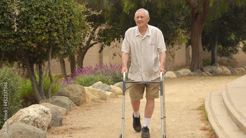 Obraz na plátne Happy, smiling senior man (82 year old Caucasian) walking in the park using a wa