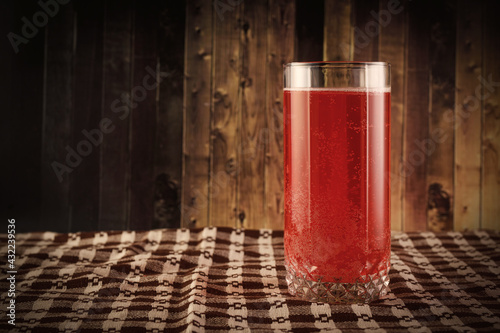Φωτογραφία The glass of red berry juice on rustic wooden background.