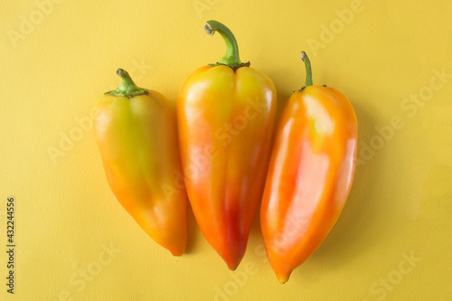 three bell peppers on yellow background . High quality photo