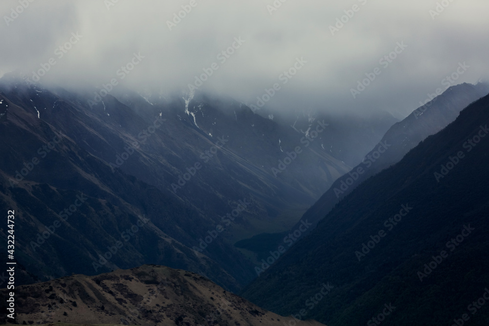Obraz premium Dark silhouettes of mountains. Dramatic mountain landscape in the clouds. Panoramic rock view.