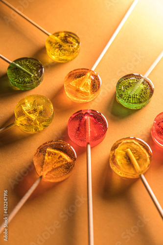 Sugar-free fruit lollipop on a minimalistic background in yellow tones. Healthy sweetness with dry fruit inside photo