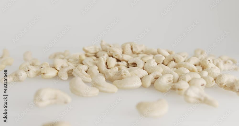 Pour raw materials Cashew nut the ingredients on the ground white background. Pour raw materials Cashew nut the ingredients on the ground white background.