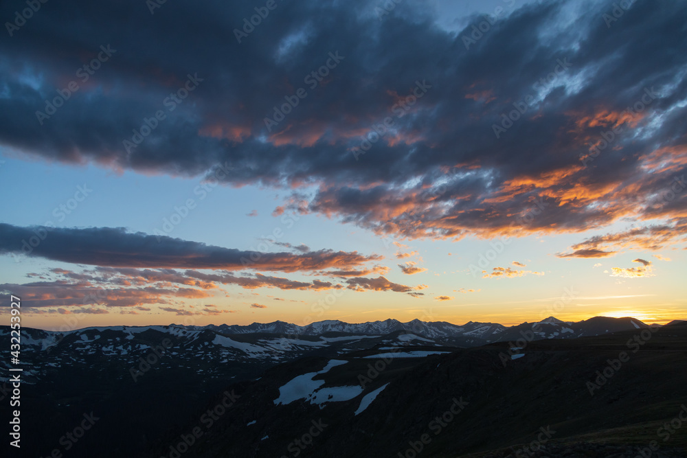 Dramatic colorful sunset and clouds over Rocky Mountain National Park mountain range, Colorado