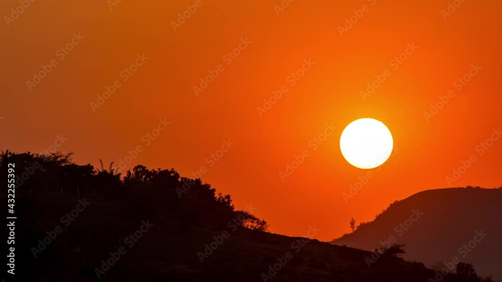 Zoomed in Time Lapse shot of Sun Setting behind the Western Ghat's Sahyadri Mountains, Maharashtra, India