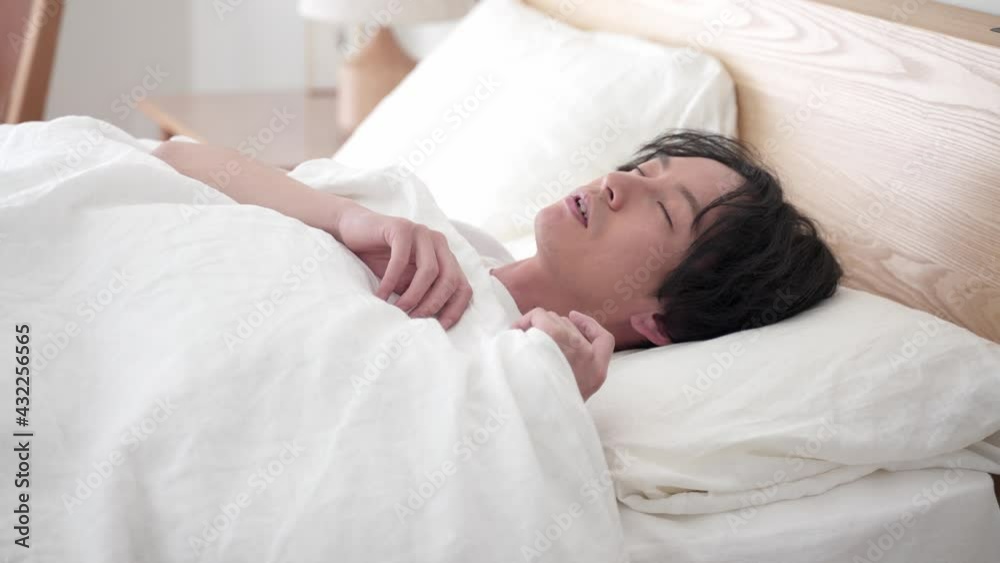 ベッドで安眠する男性 ベッドで安眠する男性