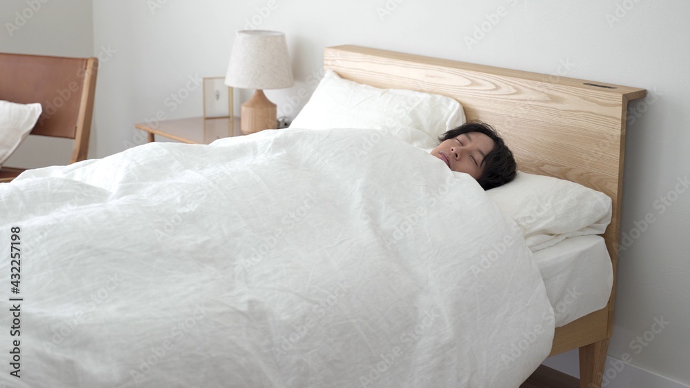 ベッドで安眠する男性 ベッドで安眠する男性