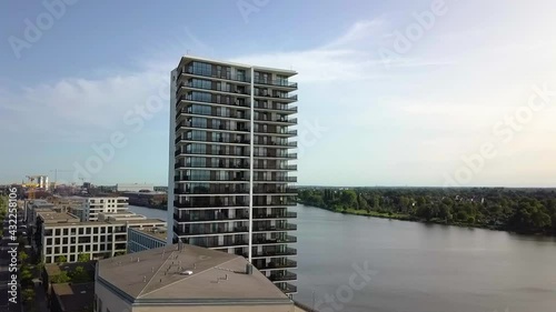 Exterior Of A High-rise Building With Boat Sailing At Weser River In Bremen, Germany. - aerial sideway photo