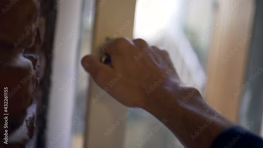 Person opening home window. Close-up hand opens knob Person opening home window. Close-up hand opens knob