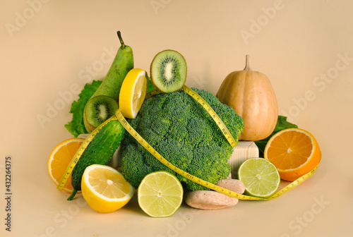 Fototapeta Naklejka Na Ścianę i Meble -  Vegetables and fruits and a measuring tape. The concept of losing weight, diet, healthy eating on white background.