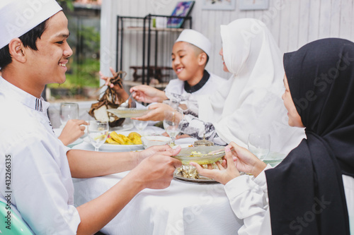 Happy asian family muslim eating together during eid mubarak celebration 