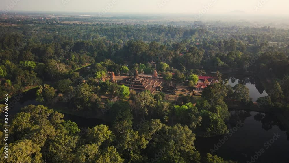 Angkorian temple, Bakong, nested in the mystic Cambodian jungle and early morning mist, aerial drone footage Angkorian temple, Bakong, nested in the mystic Cambodian jungle and early morning mist, aerial drone footage